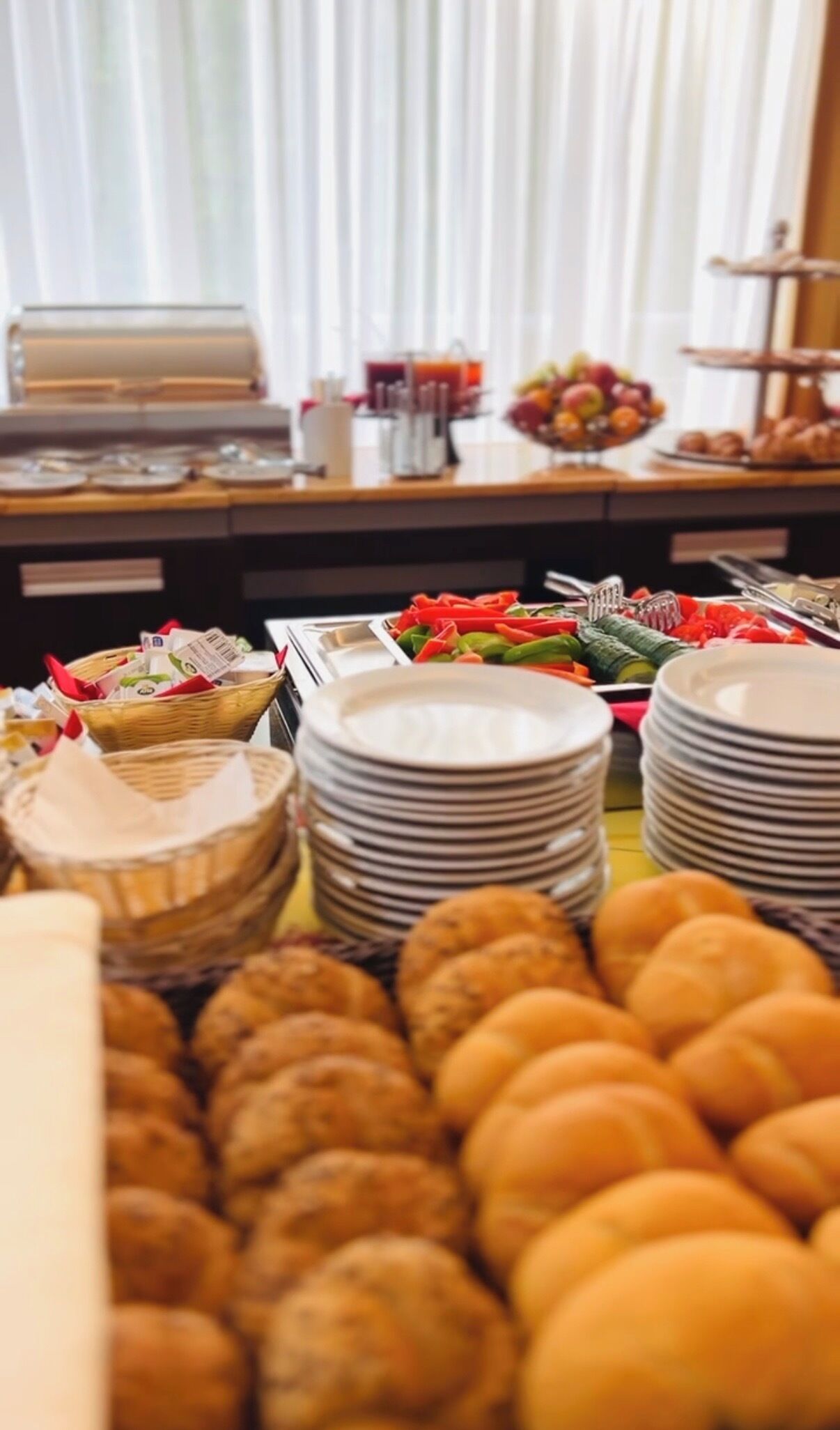A buffet with various food items including fruits, vegetables, and pastries.