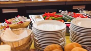 A buffet with various food items including fruits, vegetables, and pastries.