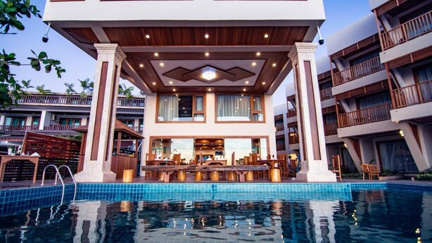 Un hôtel moderne doté d’une piscine, d’un bar et d’un espace extérieur aménagé pour se détendre.