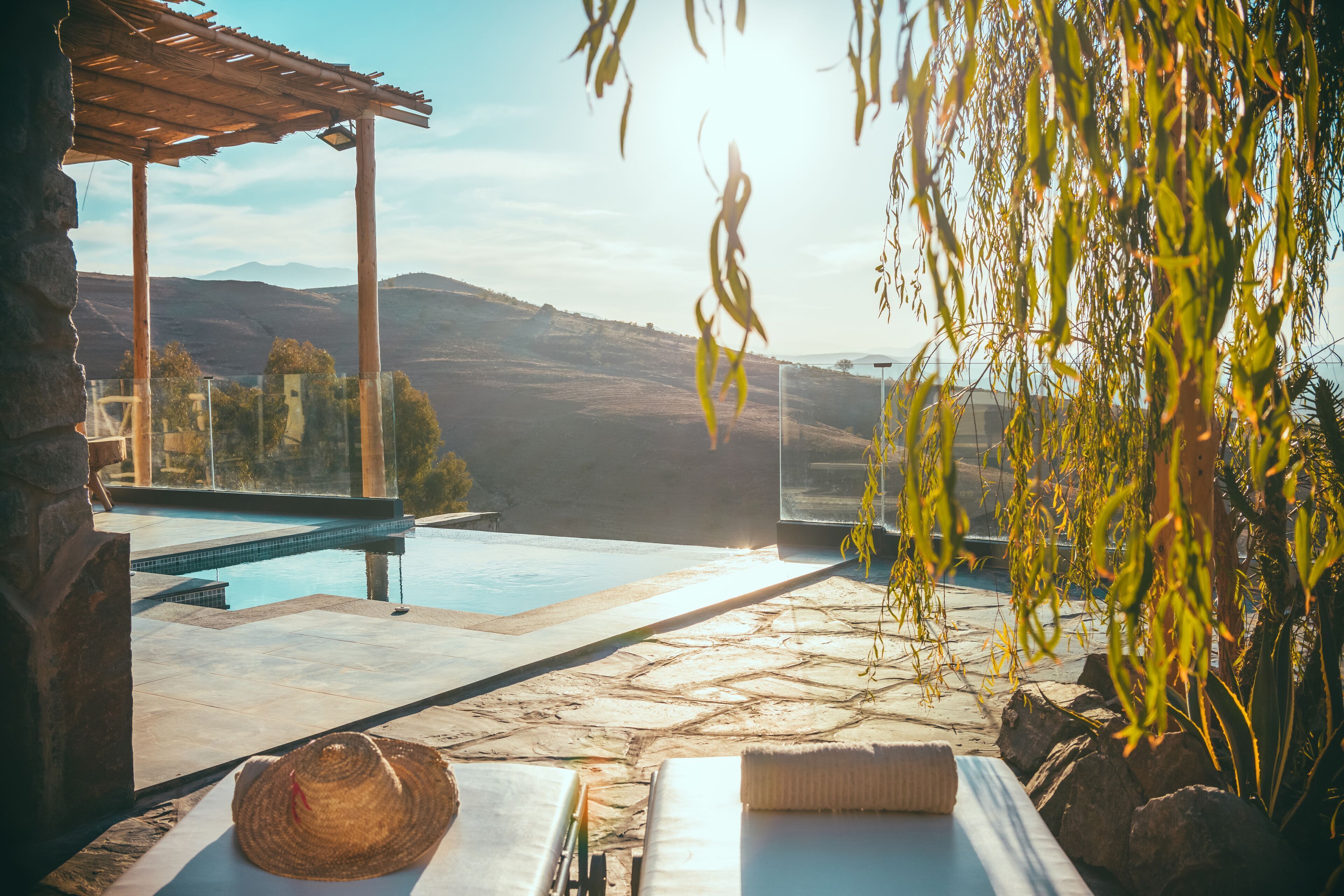 Una piscina al aire libre, sombrillas, sillones reclinables de piscina
