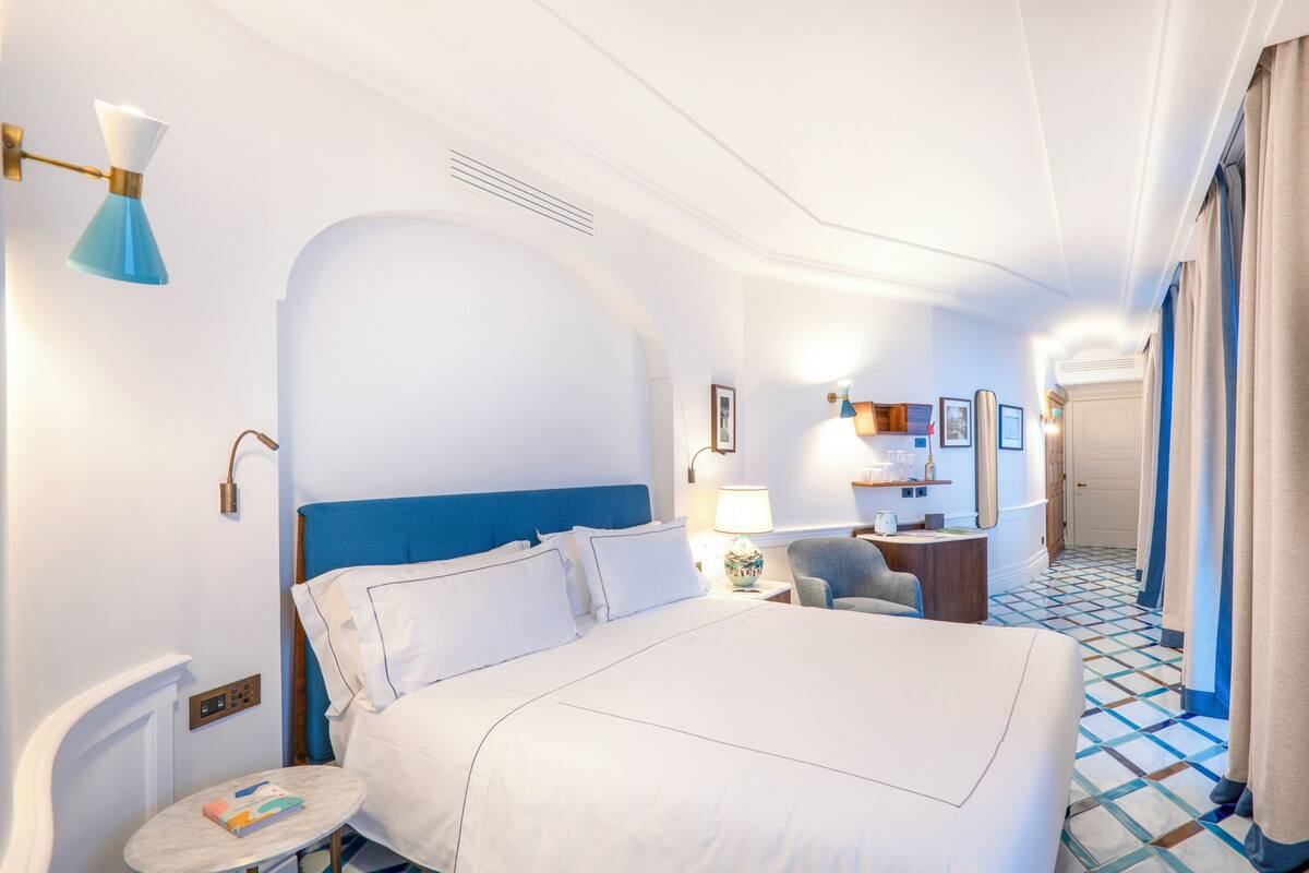 Een hotelkamer met een groot bed, een bureau, een stoel en een kleine tafel.