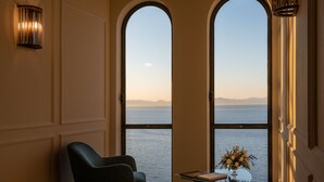 A room with a view of the sea, a round skylight, and a chair by a small table with a vase. - Borgo Santandrea (Amalfi)