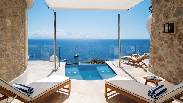 A rooftop terrace with a pool, lounge chairs, and a view of the sea. - Borgo Santandrea (Amalfi)