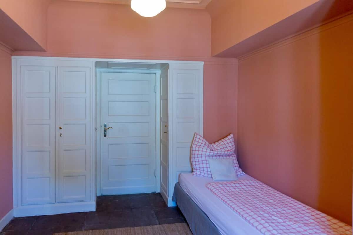Ein Schlafzimmer mit einem Bett, einem Kleiderschrank und einer Tür.