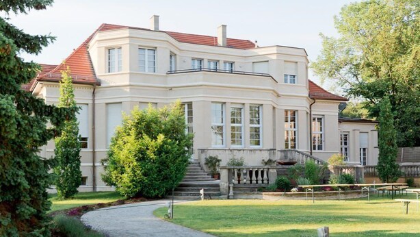 A large, two-story building with a symmetrical facade, a central entrance with steps, and a surrounding garden. - Gästehaus am Lehnitzsee (Potsdam)