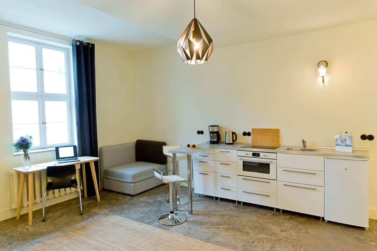 Eine moderne Küche mit Essbereich, einer Couch und einem kleinen Tisch.
