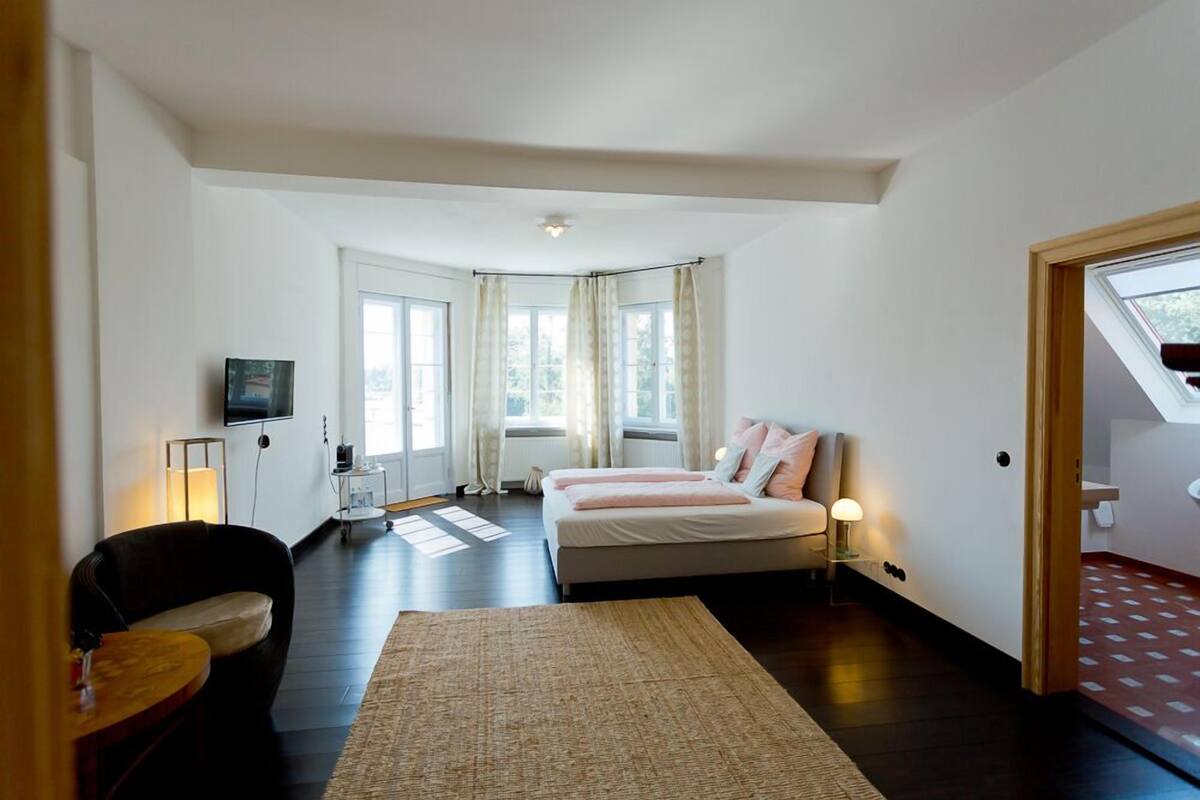 Ein Schlafzimmer mit einem Bett, einem Schreibtisch, einem Stuhl und einem Fernseher.