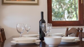 A dining table set with white plates, bowls, and wine glasses, with a wine bottle in the center. - Aparthouse - Villa Napoleon (Jelsa)