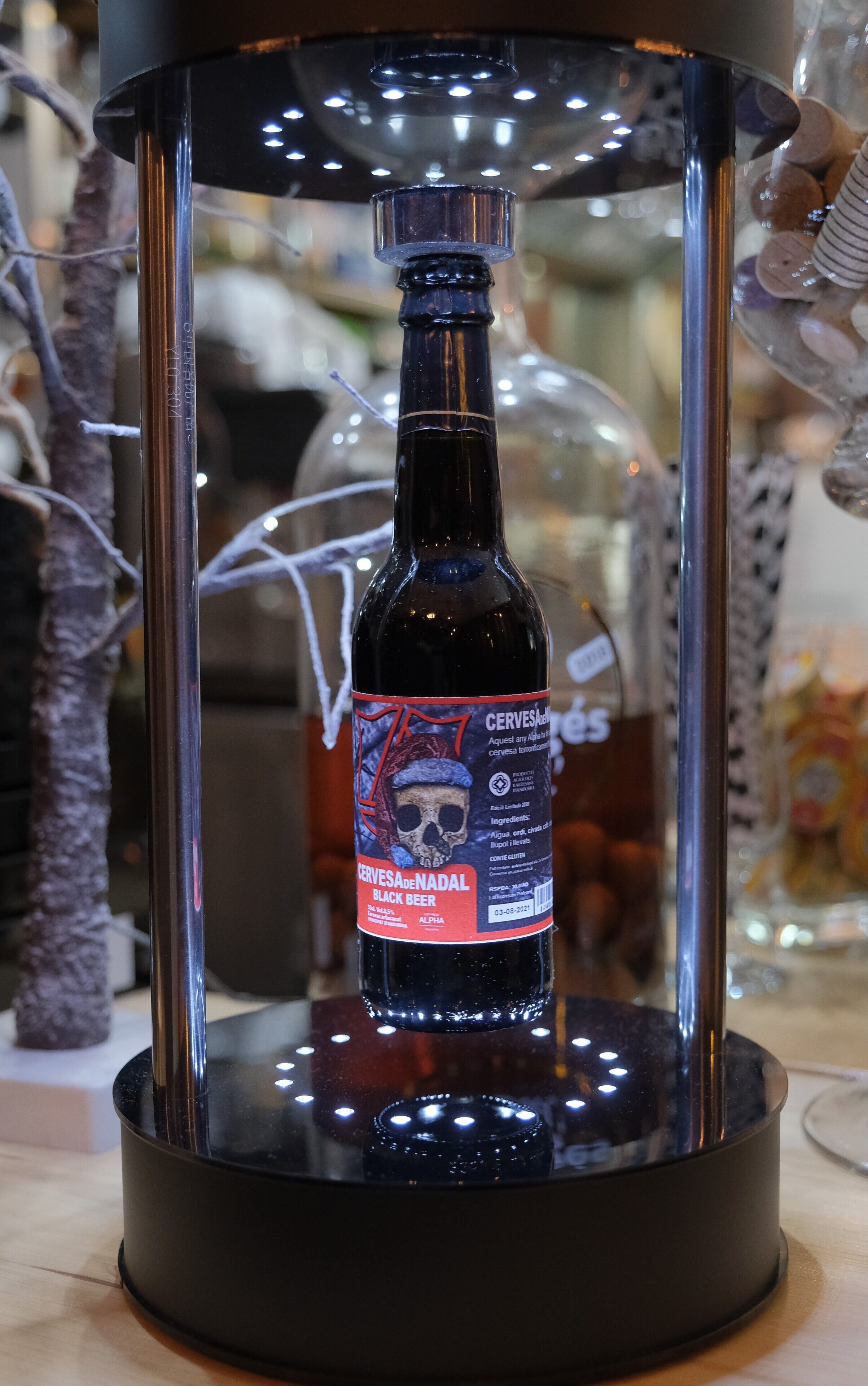 Eine Flasche Cerves De Nadal Schwarzes Bier in einer Glasvitrine.