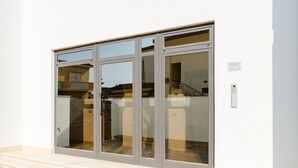 Une entrée moderne avec une porte en verre et un petit espace extérieur agrémenté de quelques marches.