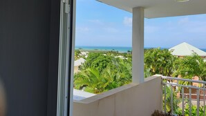 A balcony with a view of a beach and palm trees. - VillaRosa Guadeloupe (Sainte-Rose)