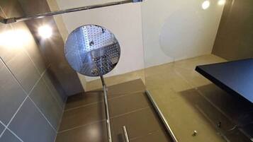 Una habitación con un espejo grande, un poste de metal y un banco azul.