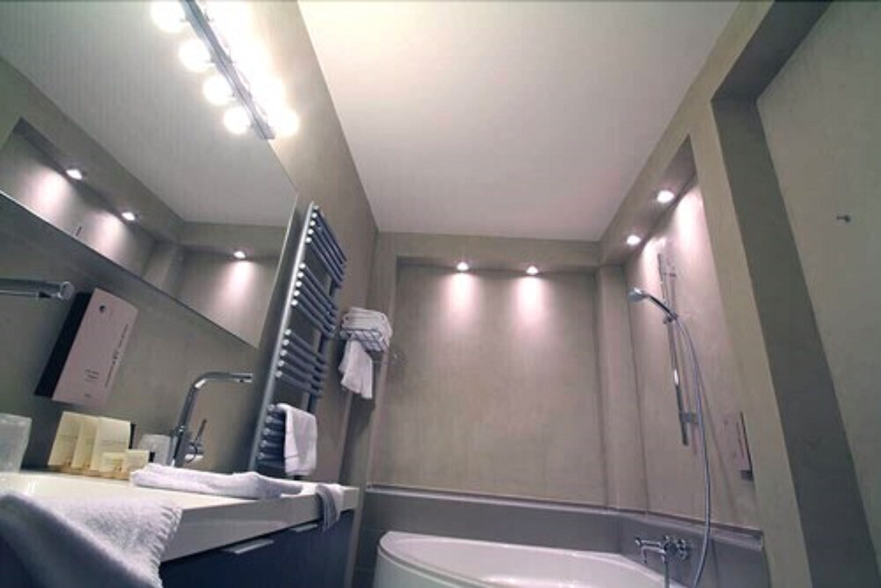 A modern bathroom with a bathtub, a sink, and a mirror.