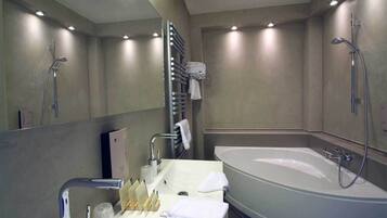 A modern bathroom with a large bathtub, a sink with toiletries, and a towel rack.