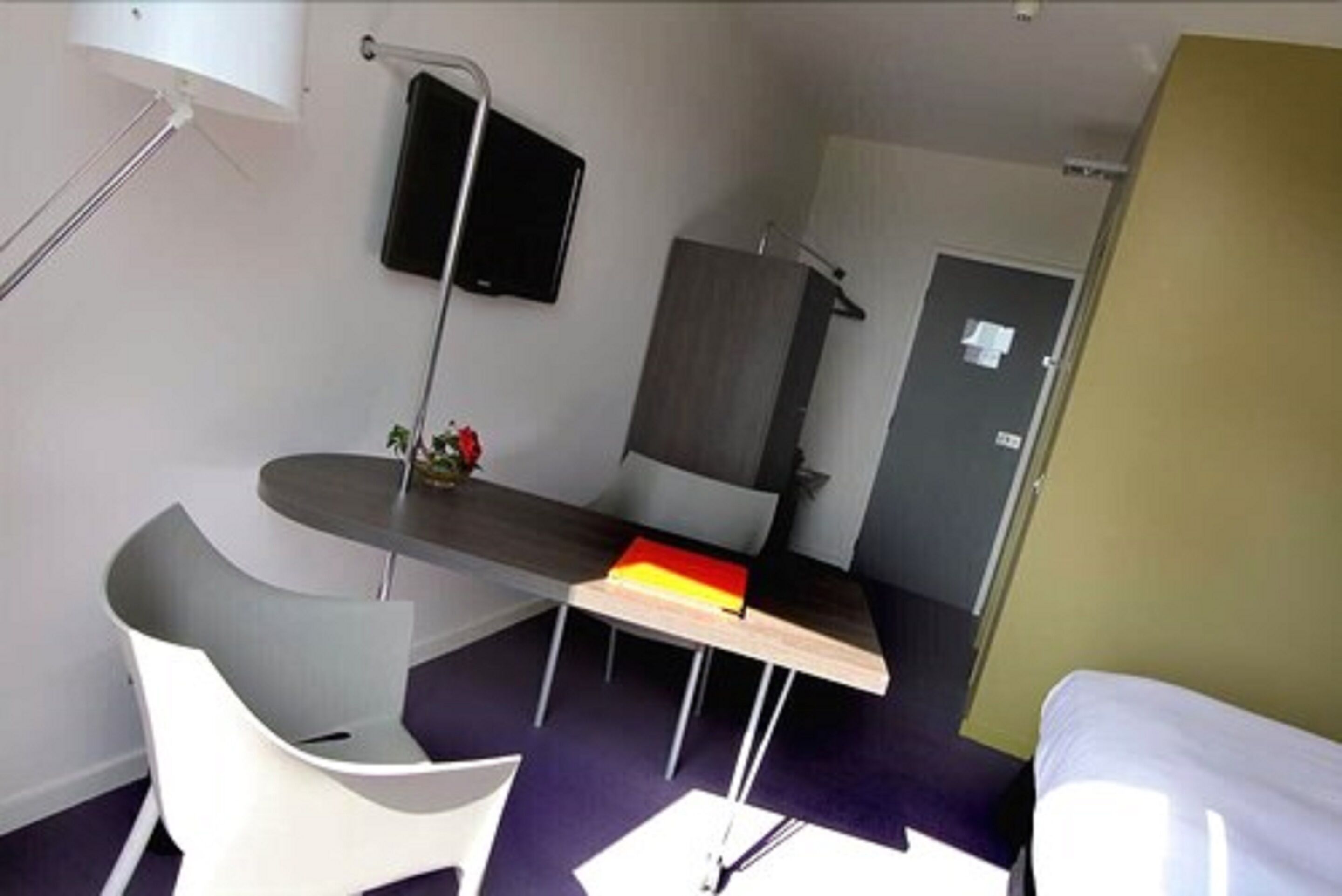 A compact room with a bed, a desk, and a chair.