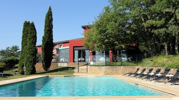 Una piscina al aire libre de temporada, sombrillas, tumbonas