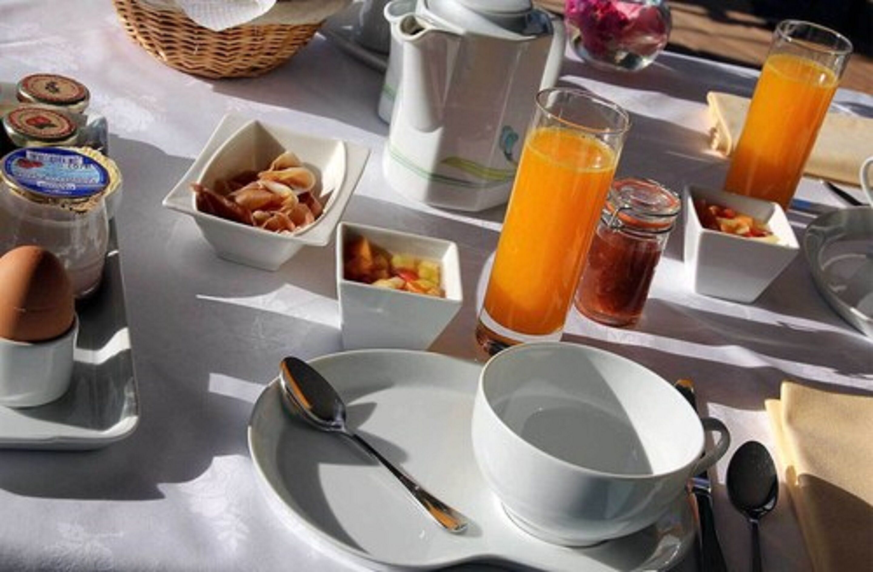 A breakfast table with various food items, a pitcher, and glasses of orange juice.