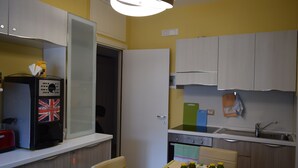 A compact kitchen with a microwave, toaster, and a refrigerator. - English Inn rooms (Sorrento)