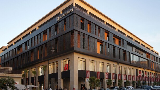 A modern building with multiple floors, featuring prominent signage for 'CARREDEEN' and 'H&M'. - Appart F3 Deluxe Carré Eden (Marrakech)