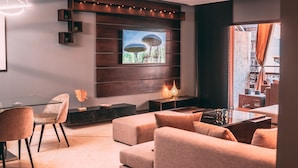 A modern living room with a glass coffee table, a sofa, and a TV mounted on a wooden wall. - Appart F3 Deluxe Carré Eden (Marrakech)