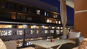 An outdoor seating area with wicker furniture and a table, surrounded by a decorative fence. - Appart F3 Deluxe Carré Eden (Marrakech)