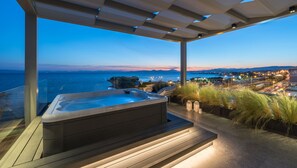 A hot tub under a pergola with a view of the ocean and city lights. - Urban Suites (Alimos)