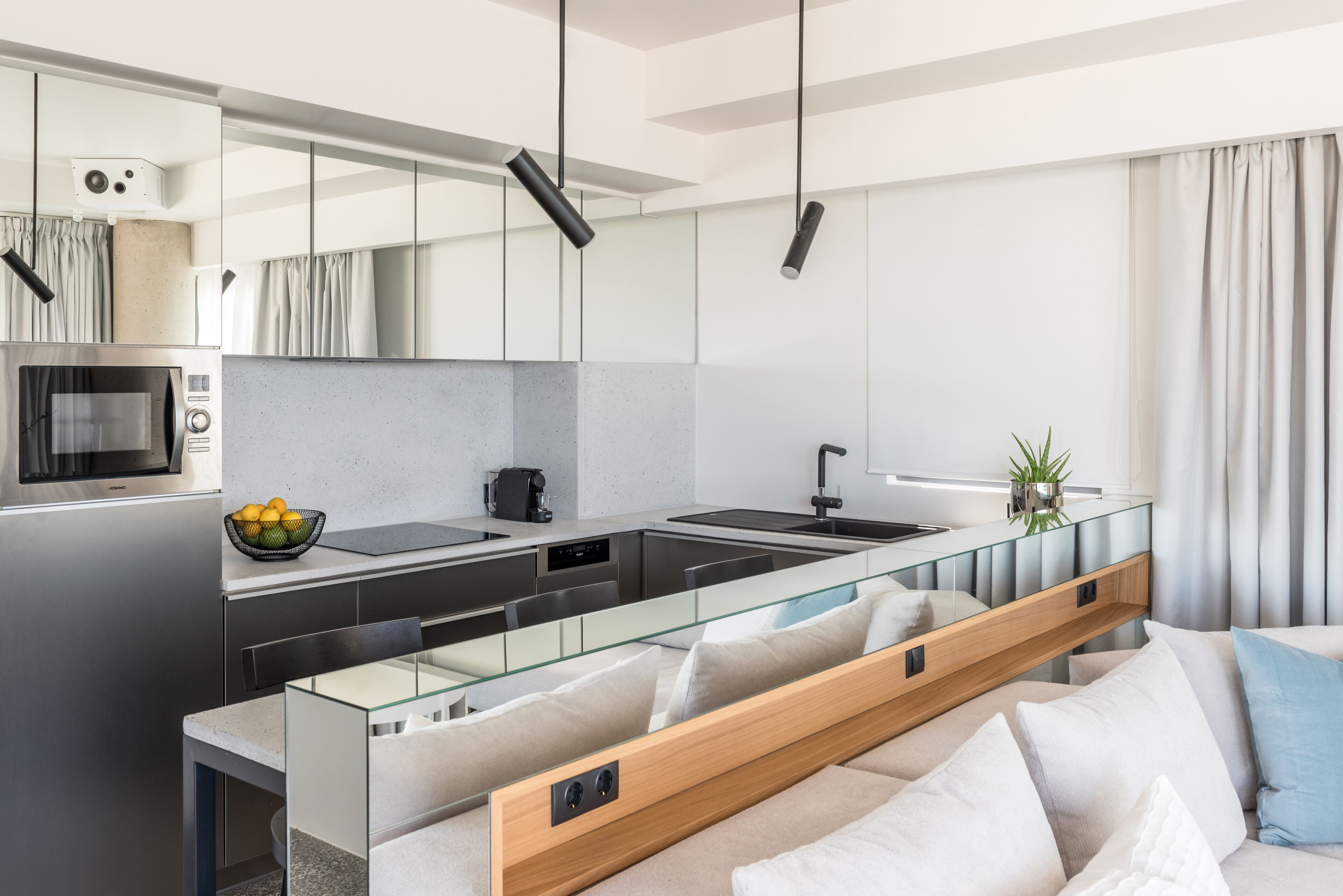 A modern kitchen with a glass island, stainless steel appliances, and a minimalist design.
