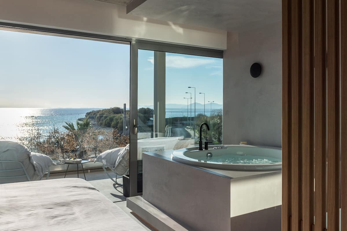 A modern bathroom with a large bathtub and a view of the sea.