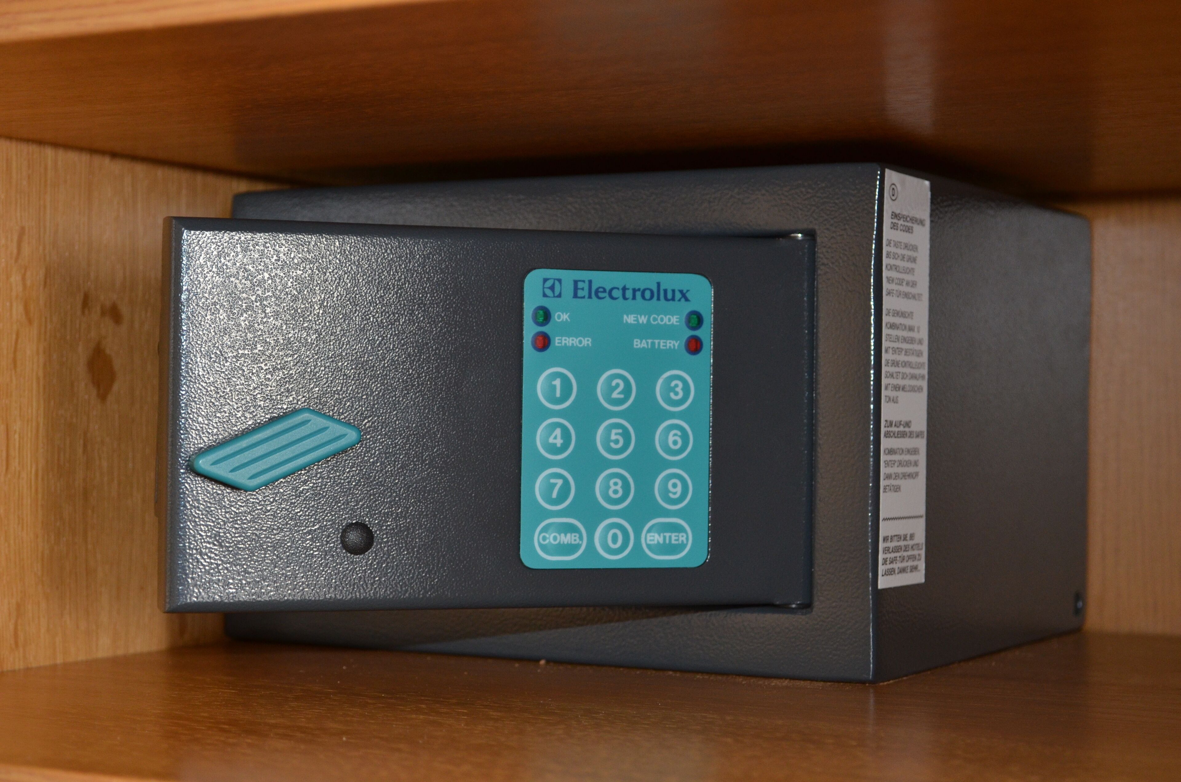 Un dispositivo electrónico negro con teclado y un botón azul, etiquetado como 'Electrolux'.