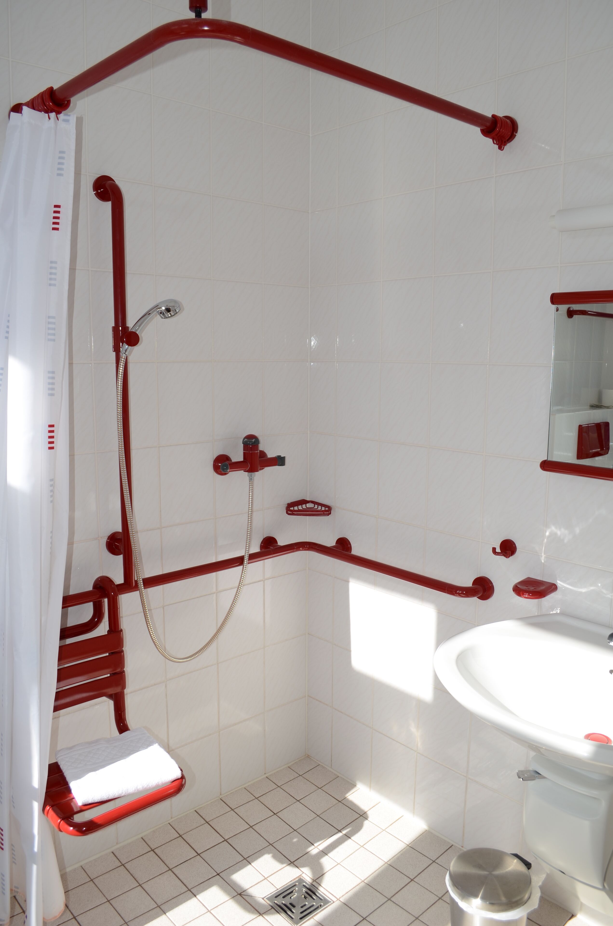 A bathroom with a shower, toilet, and sink.