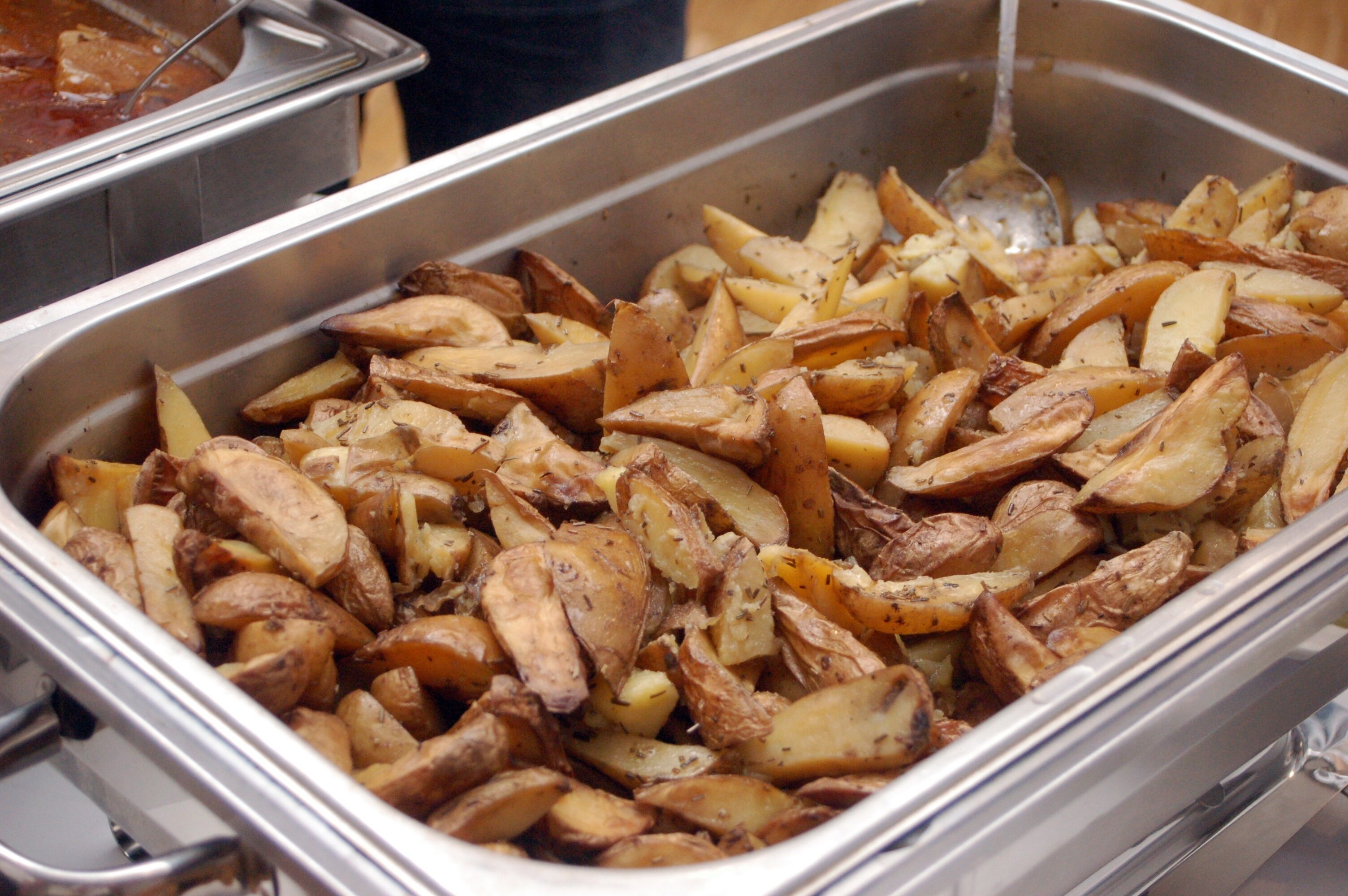 Ein Buffet mit Bratkartoffeln und einem Löffel.