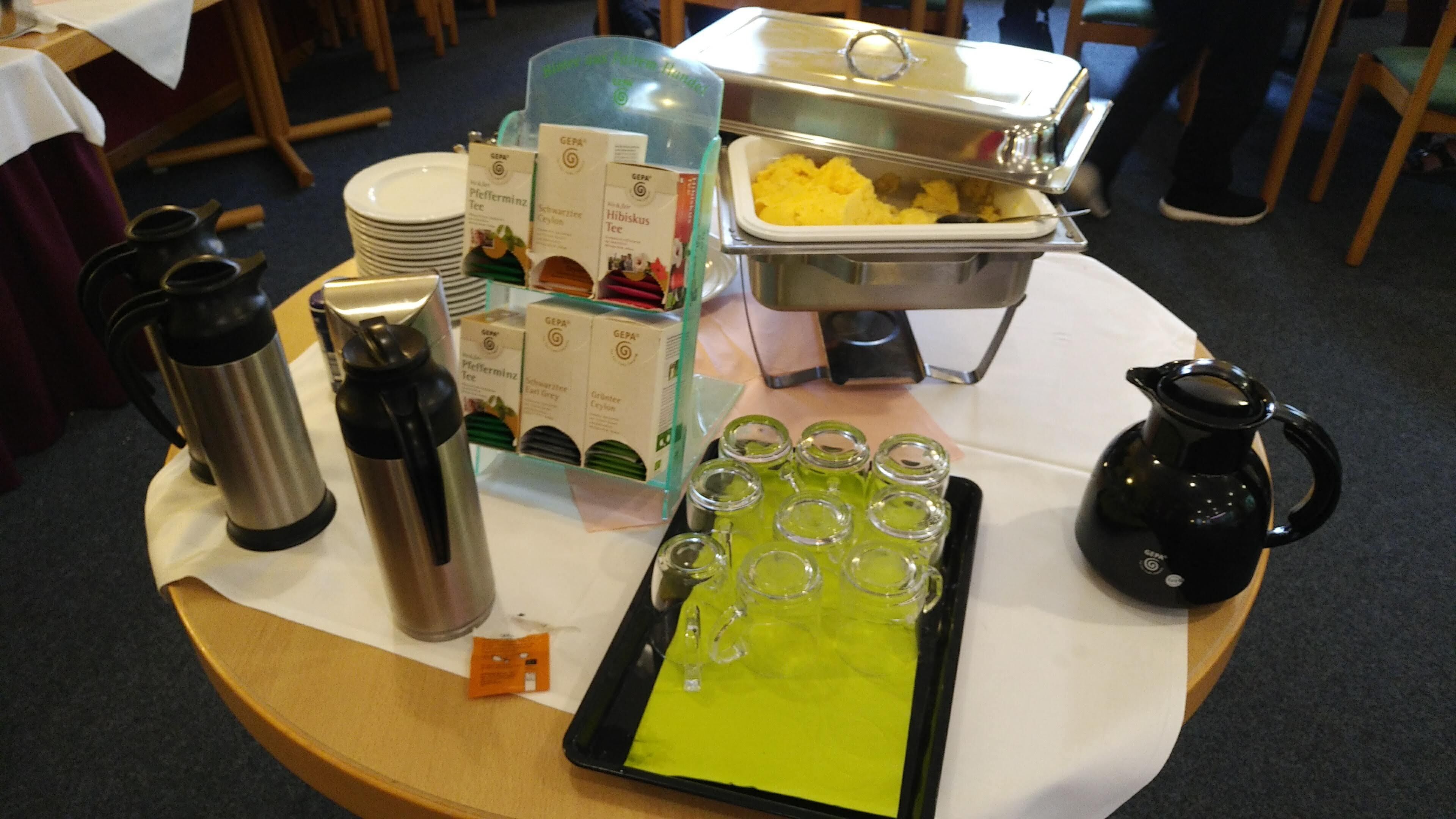 A buffet table with various food items, a coffee station, and a selection of beverages.