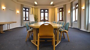 A conference room with a large oval table, wooden chairs, and a whiteboard. - Stiftsberg Bildungs und Freizeitzentrum (Kyllburg)