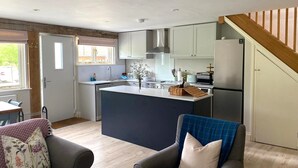 A modern kitchen with a central island, white cabinets, and stainless steel appliances.