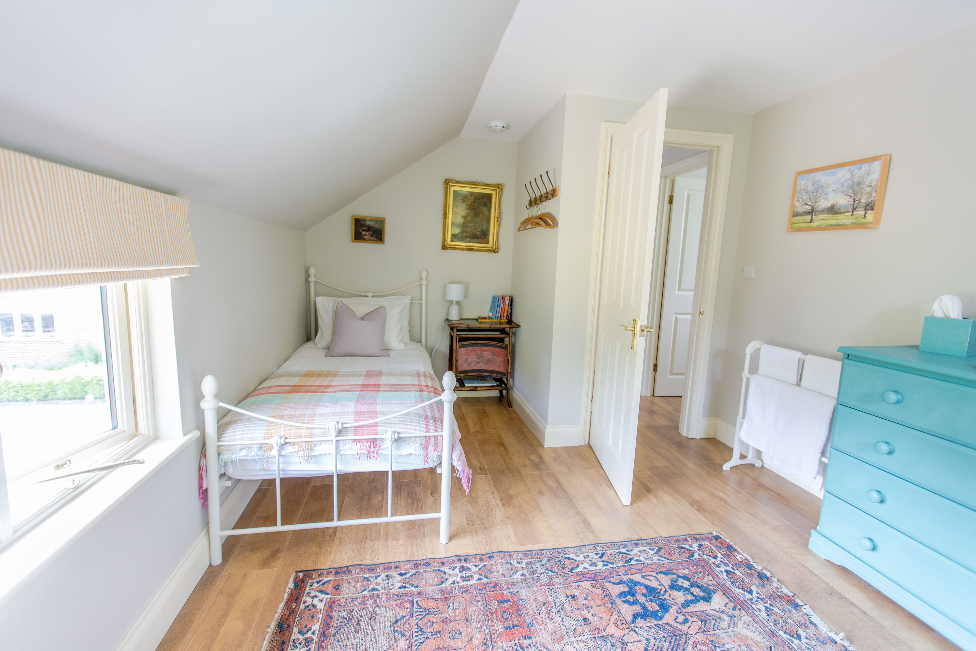 Un dormitorio con cama, cómoda, mesita de noche, ventana y puerta.