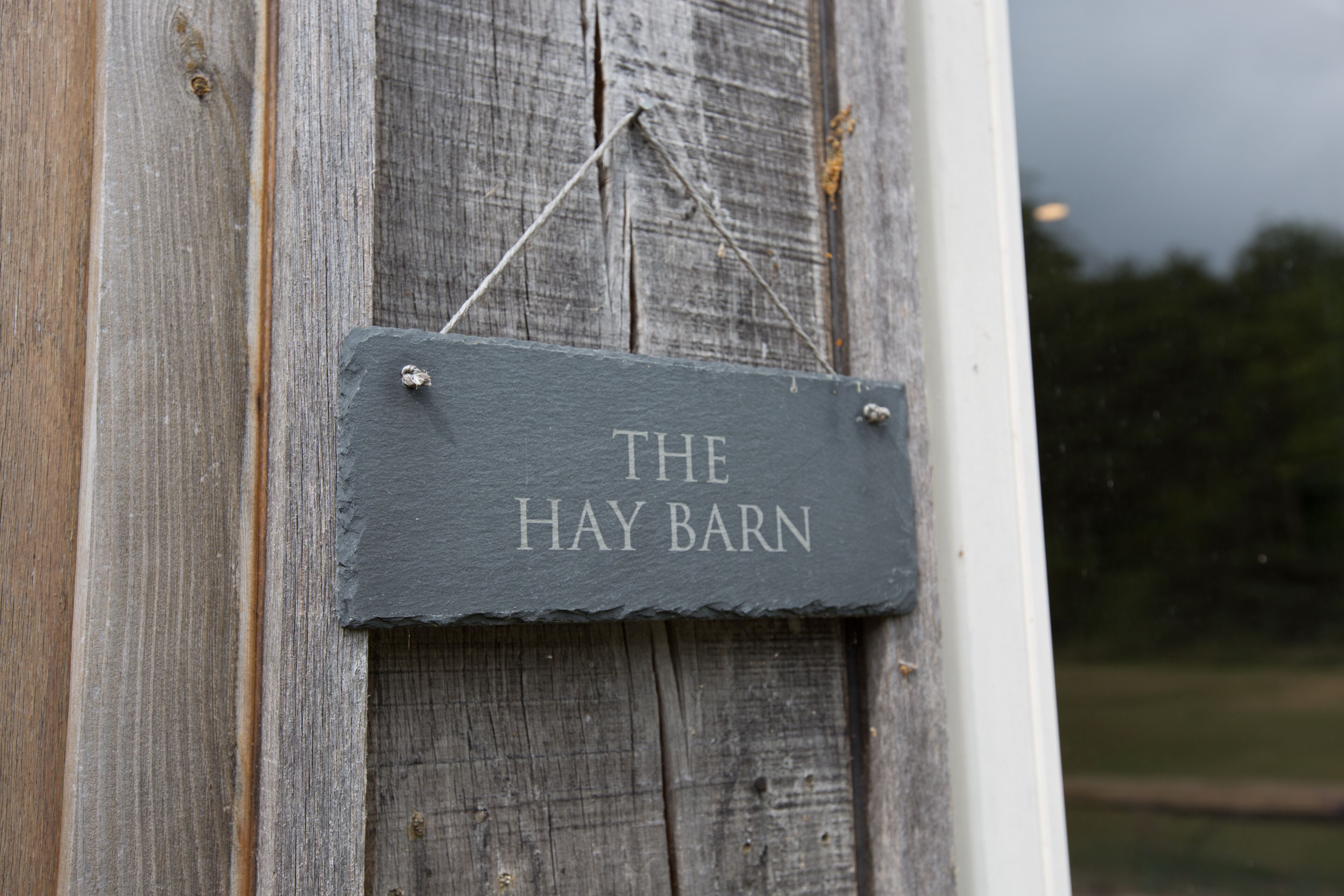 A rustic wooden barn with a sign that reads "THE HAY BARN".