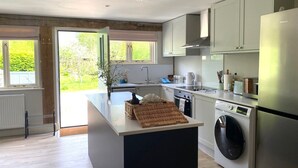 A modern kitchen with a central island, built-in appliances, and a view of the outdoors.