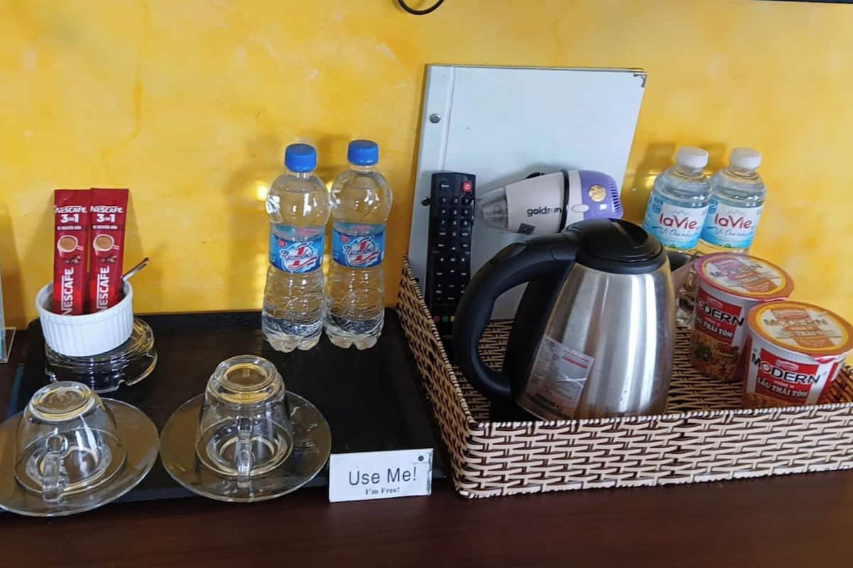 Ein Tisch mit Kaffeetassen, Wasserflaschen, einem Wasserkocher und Gewürzen.