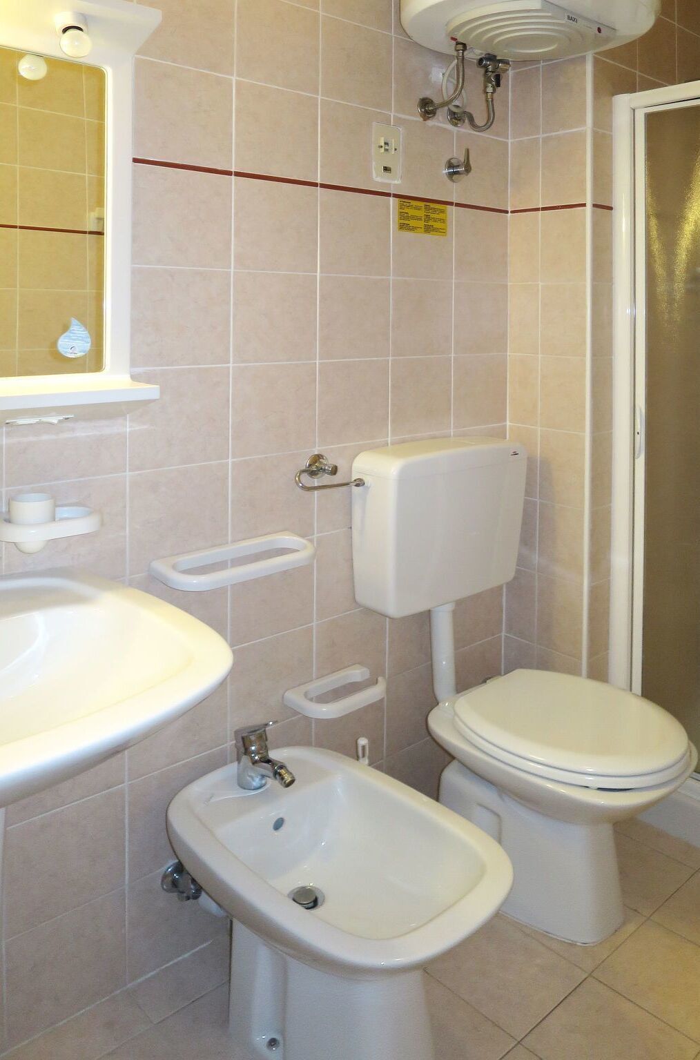 Ein Badezimmer mit Waschbecken, Bidet, Toilette und Spiegel.