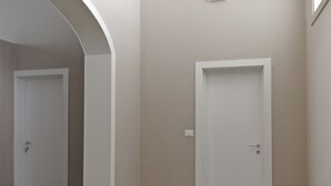 A hallway with a white door and a light switch on the wall. - B&B Mamma Carolina (Sanarica)