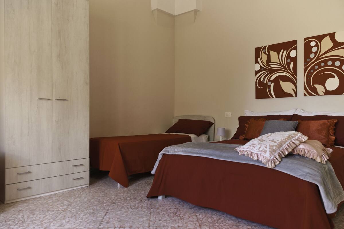 Un dormitorio con dos camas individuales, un armario y decoración mural.