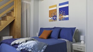 A bedroom with a bed, nightstand, and a wooden staircase. - B&B Mamma Carolina (Sanarica)