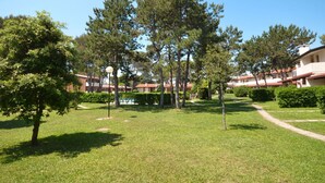 A well-maintained outdoor area with a lawn, trees, and a pool. - Beautiful apartment in villa for 8 guests with A/C, pool, TV, terrace and pets allowed (San Michele Al Tagliamento)