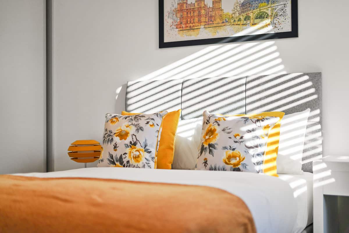 A bed with floral-patterned pillows and a striped headboard.