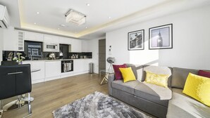 Una sala de estar moderna con un sofá gris, cojines amarillos y una alfombra gris.