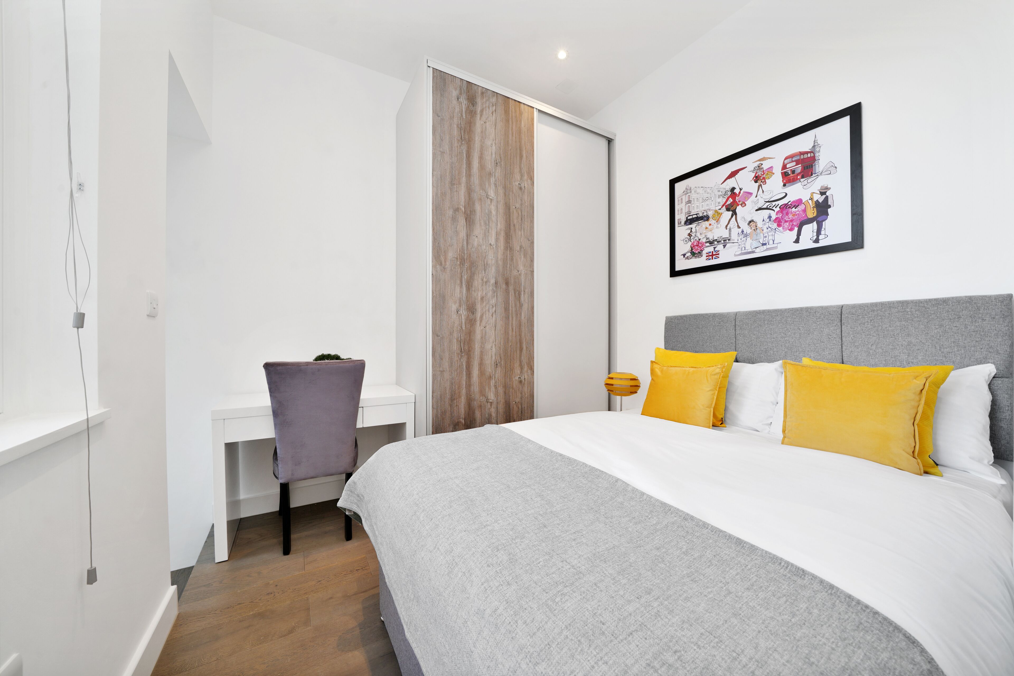Een slaapkamer met een bed, een bureau en een stoel.