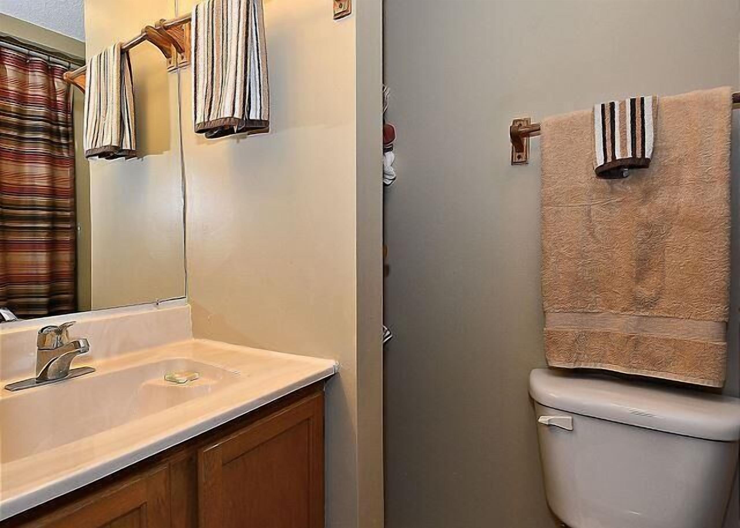 A bathroom with a sink, mirror, and toilet.