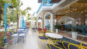 An outdoor patio area with tables and chairs, a pool, and potted plants. - TURI STAYpoint (Nghia Lo)