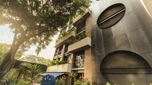 Un edifici modern amb un disseny circular únic, envoltat de vegetació exuberància i arbres.