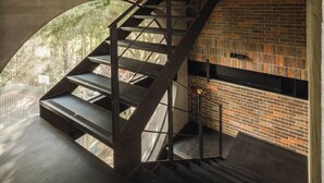 Una escala amb baranes metàl·liques que condueix a una paret de maó.